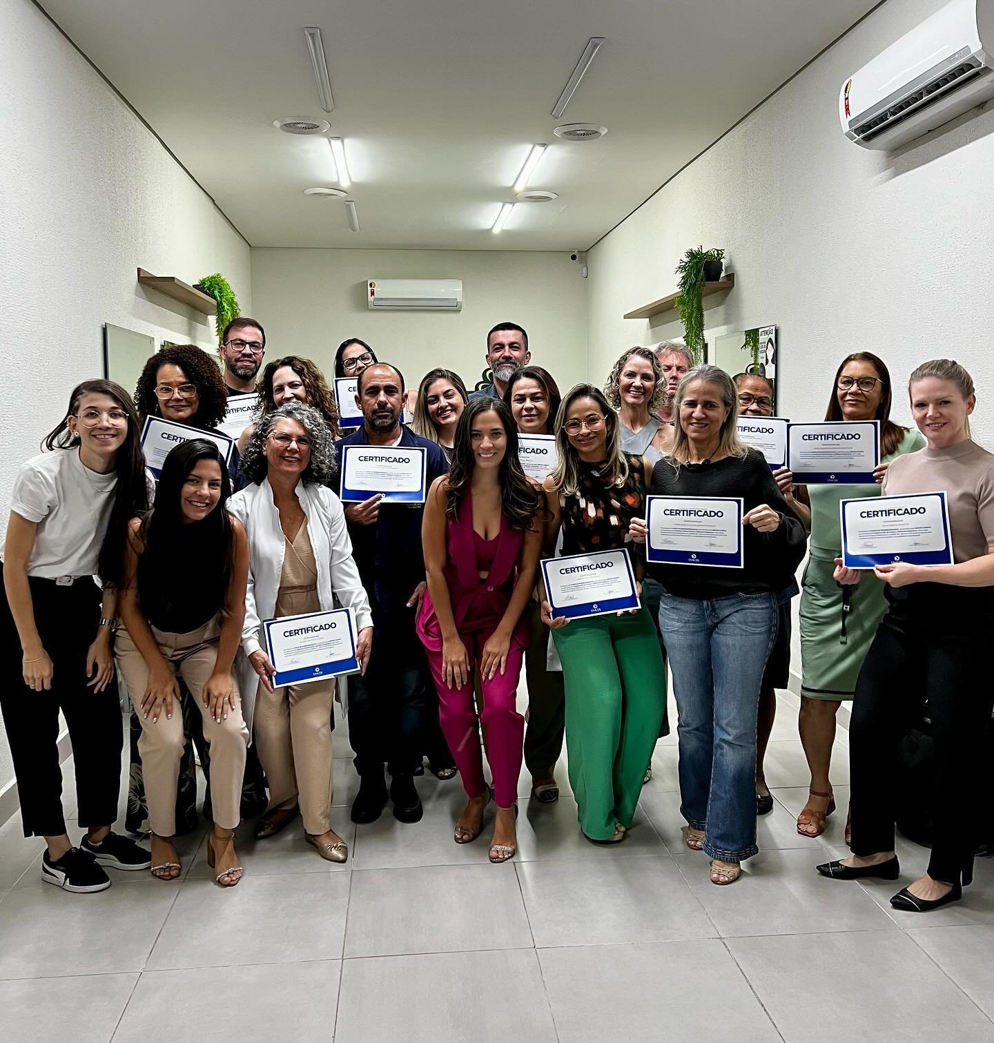 Turma formada pela Salut segurando os certificados no corredor da escola